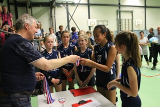 Wedstrijdleider Gerard Witte deelt de medailles uit